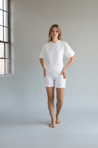 Care Design white cotton short-sleeve, short-leg bodystocking with shoulder zippers and leg band for secure fit.